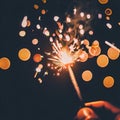 Hand holding burning Sparkler blast on a black bokeh background at night,holiday celebration event party,dark vintage tone Royalty Free Stock Photo