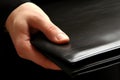 Hand holding business folder, black file close-up. Person showing empty purse, leather open Royalty Free Stock Photo