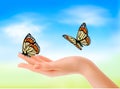 Hand holding a butterflies against a blue sky. Royalty Free Stock Photo