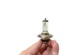 Hand holding car halogen light bulb vehicle spare parts on white background Royalty Free Stock Photo