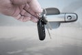 Hand Holding Car Keys in front of Car Door Royalty Free Stock Photo