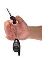 Hand holding car keys and a remote control