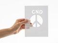 Hand holding card with peace symbol and cnd logo Royalty Free Stock Photo