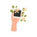 Hand is holding a card with a poloroid and a stem with leaves and flowers. Vector illustration on white background.