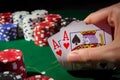 hand holding cards at poker table with chips stacked Royalty Free Stock Photo