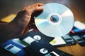 Hand is holding CD disk background with floppy on the table