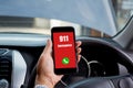 Hand holding cell phone with emergency number 911 in car Royalty Free Stock Photo