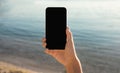 Hand Holding Cellphone With Blank Screen Against Sea Beach Outdoor Royalty Free Stock Photo