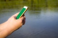 Hand Holding Cellphone With Blank Screen Showing Mobile App Against Sea Beach Outdoor. Cropped, Mockup Royalty Free Stock Photo