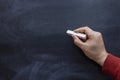 Hand holding a chalk on a blank blackboard. chalk Board Royalty Free Stock Photo