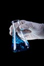 Hand holding chemical flask stirring blue liquid Royalty Free Stock Photo