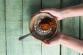 Hand holding chili powder and crushed red pepper in bowl