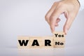 Hand holding chooses wooden block cubes with War word yes or no Royalty Free Stock Photo