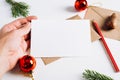 Hand holding Christmas blank greeting card mock-up for invitation or wish, close-up. Happy new year composition template