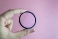 hand holding clear camera filter isolated on pink Royalty Free Stock Photo