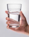 Hand holding a clear glass of water