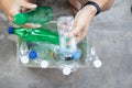 Hand  holding clear and green recyclable plastic bottle putting in paper garbage bin for recycling. waste management and plastic Royalty Free Stock Photo