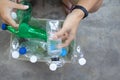 Hand  holding clear and green recyclable plastic bottle putting in paper garbage bin for recycling..waste management and plastic Royalty Free Stock Photo