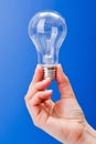 Hand holding a clear incandescent light bulb Royalty Free Stock Photo