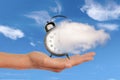Hand holding a clock dissolving away in a cloud. Time flies time management concept. Surreal collage