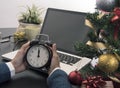 Hand holding clock midnight for Christmas day in the office. Royalty Free Stock Photo