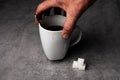 Hand Holding Coffee Mug with Sugar Cubes Royalty Free Stock Photo