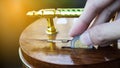 Hand holding coin drops into a wooden piggy bank. Saving coin concept. Conceptual saving money for business or life in future. Royalty Free Stock Photo