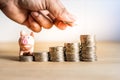 A hand holding coin to saving money for future with piggy bank on stack money,Success of life in future Royalty Free Stock Photo