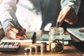 hand holding coins puting into jug glass for saving money. concept finance