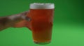 Hand holding cold beer, green screen background, studio shot, advertisement Royalty Free Stock Photo