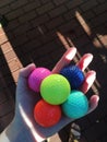 Hand holding colorful golfballs