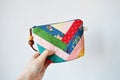 Hand holding colorful patchwork notions bag with zipper and wooden beads