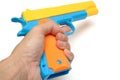 A hand holding a colorful toy pistol hand gun Royalty Free Stock Photo