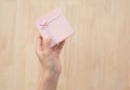 Hand holding colourful vintage gift box on wooden table