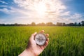 Hand holding compass and rice field sunset Royalty Free Stock Photo