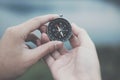 hand holding compass for searching direction outdoor. man seeking way with nature background. travel lifestyle, summer vacation c Royalty Free Stock Photo