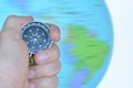 Hand holding a compass with a spinning globe Royalty Free Stock Photo