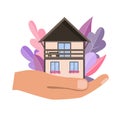 Hand holding cosy home house in palm. Vector illustration. Modern flat leaves backgropund, dream home concept