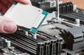 Hand holding a CPU and inserts it into the motherboard Royalty Free Stock Photo