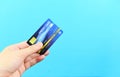 Hand holding credit card on blue background - payment online shopping paying with credit card technology e wallet concept Royalty Free Stock Photo