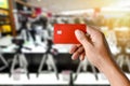 A hand holding credit card on blurred camera shop store Royalty Free Stock Photo