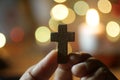 Hand holding a cross. On blurry background of colorful bokeh lights. Love passion, faith and hope concept Royalty Free Stock Photo