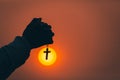 Hand holding the cross, the symbol of the blessing of Jesus, the symbol of supplication and faith, the symbol of the cross in the