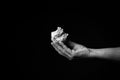 Hand holding crumpled ball of paper against black background Royalty Free Stock Photo