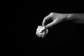 Hand holding crumpled ball of paper against black background Royalty Free Stock Photo