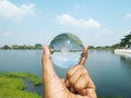 Hand holding crystal ball at Suan Luang Rama IX Public Park in Bangkok, Thailandat