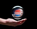 Hand holding a crystal glass forecasting ball to predict the result of the election