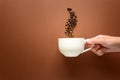 Hand holding cup of coffee with smoke from coffee beans brown paper background Royalty Free Stock Photo