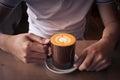 hand holding a cup of coffee top view surface heart shape in wooden background