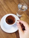 Hand holding a cup turkish coffee on table Royalty Free Stock Photo